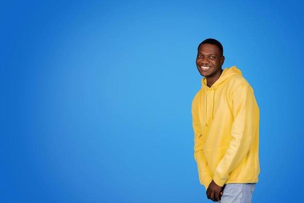 Cheerful millennial african american guy in sweatshirt has fun enjoy free time with free space