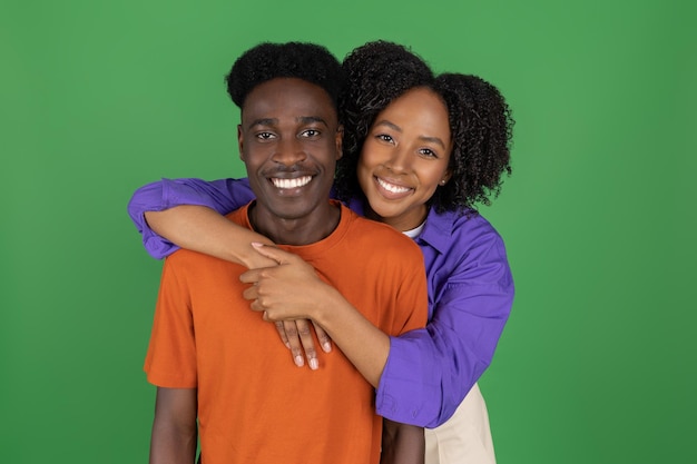 Cheerful millennial african american lady hugging boyfriend in casual enjoy date