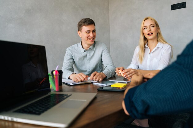 Cheerful millennial business team discussing new idea collaborating working together unrecognizable colleague leader explaining male and female coworkers