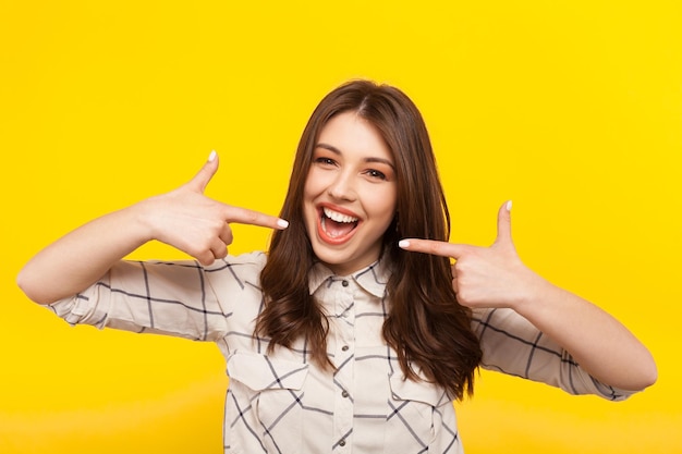 Photo cheerful model pointing at herself