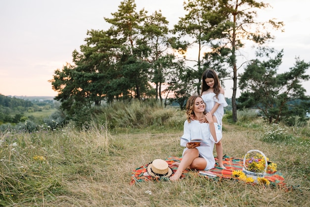 Photo cheerful mother and her little daughter having fun together in the summer surface