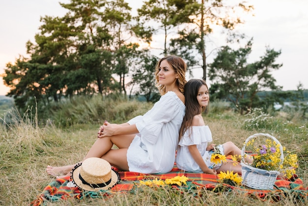 쾌활한 어머니와 그녀의 작은 딸이 여름 표면에서 함께 재미
