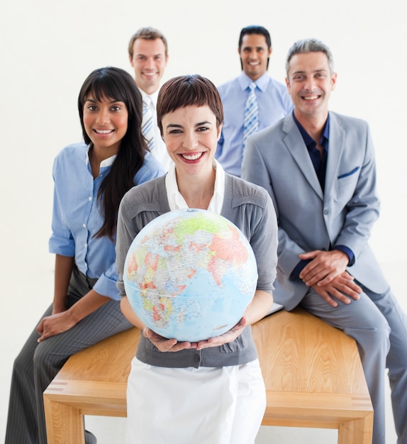 Photo cheerful multi-ethnic business people holding a terrestrial globe