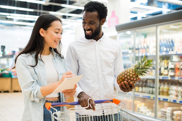 写真 陽気な多民族カップルのスーパーで商品を購入