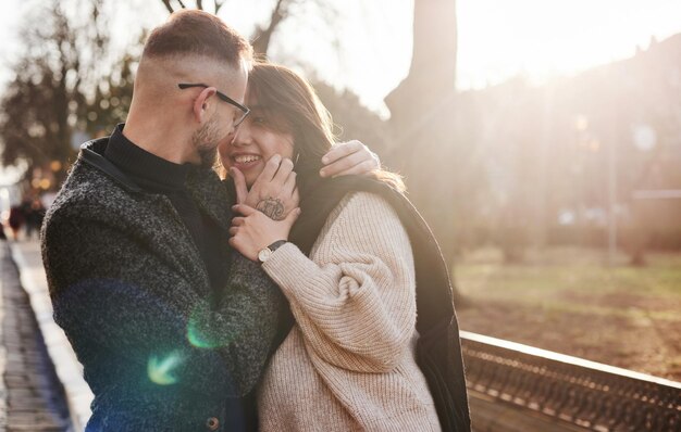 Cheerful multiracial couple embracing each other outdoors in the city. Asian girl with her caucasian boyfriend.