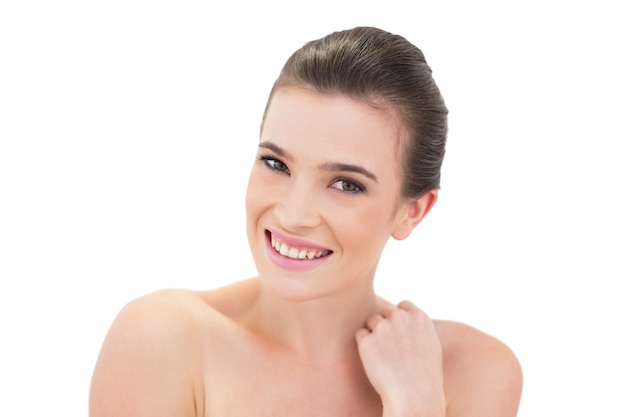 Cheerful natural brown haired model touching her shoulder