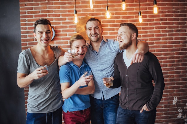 Cheerful old friends communicate with each other  glasses of whiskey in pub.   entertainment and lifestyle