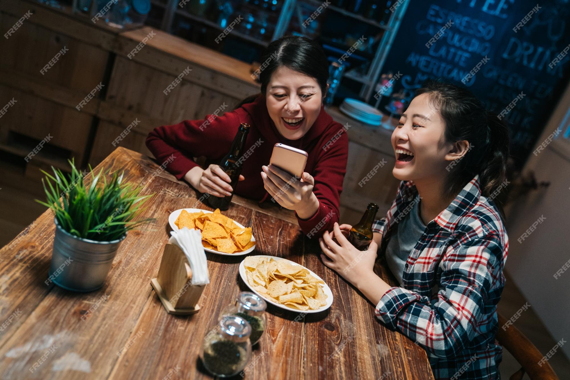 Premium Photo | Cheerful old girl friends having fun with smartphone and drinking draft beer in pub at night eating junk food chips. young women sisters laughing joyful with funny photo on Premium Photo | Cheerful old girl friends having fun with smartphone and drinking draft beer in pub at night eating junk food chips. young women sisters laughing joyful with funny photo on