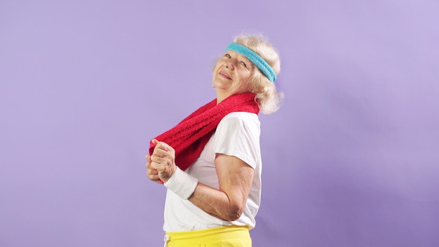 Веселая старушка с повязкой на голове любит фитнес.