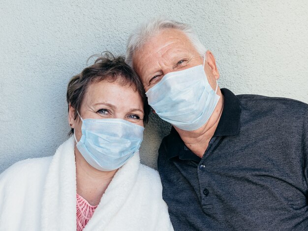 Cheerful old man and woman in medical masks