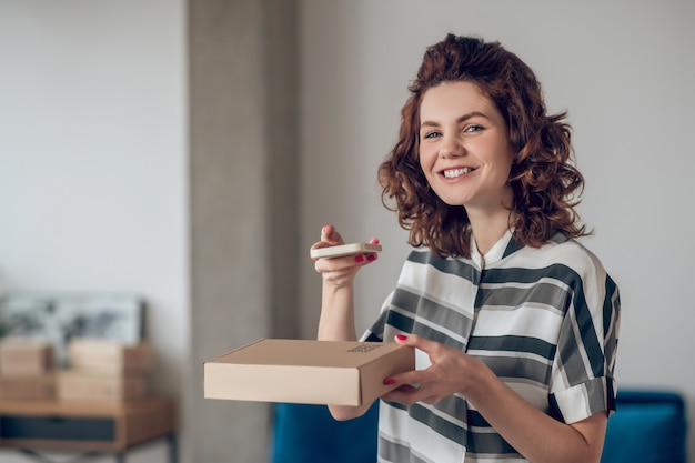 Cheerful online store worker posing for the camera in the workplace