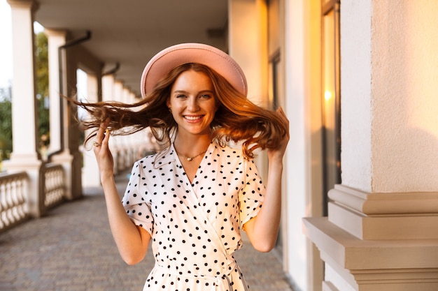 cheerful optimistic happy positive young redhead woman walking by street outdoors.