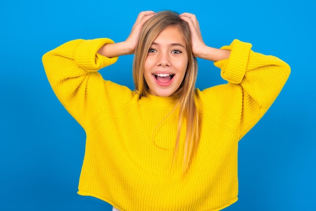 Cheerful overjoyed teen girl reacts rising hands over head after receiving great news