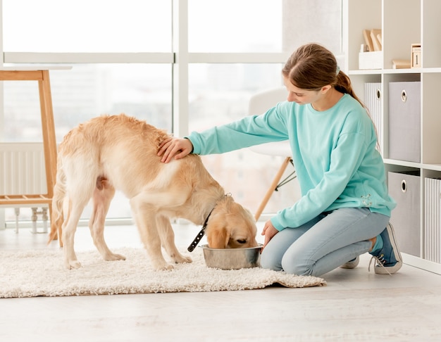 陽気な飼い主がかわいい犬に餌をやる