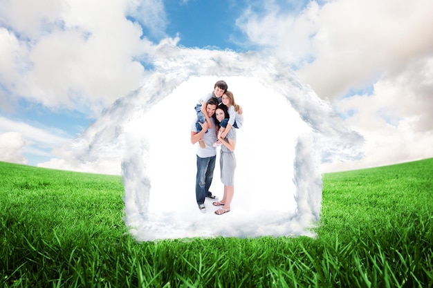 Photo cheerful parents giving their children piggyback ride against green field under blue sky