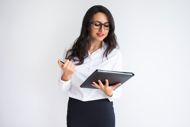 Cheerful pensive business lady examining papers