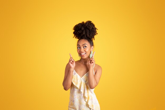 Cheerful pensive millennial black lady point fingers up on free space thinks got idea