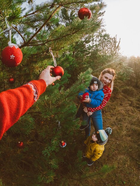 森のクリスマスツリーの近くの陽気な人々