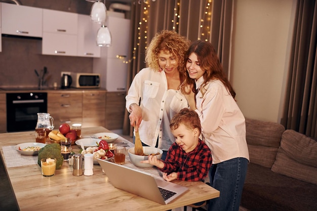 Cheerful people having happy weekend Family of mother daughter and son is on the kitchen at evening time