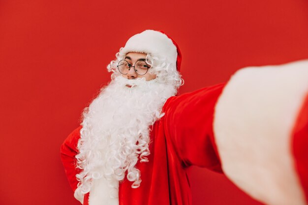 Cheerful photogenic Santa Claus is posing for a selfie