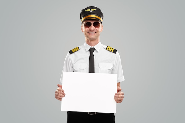 Cheerful pilot with blank banner