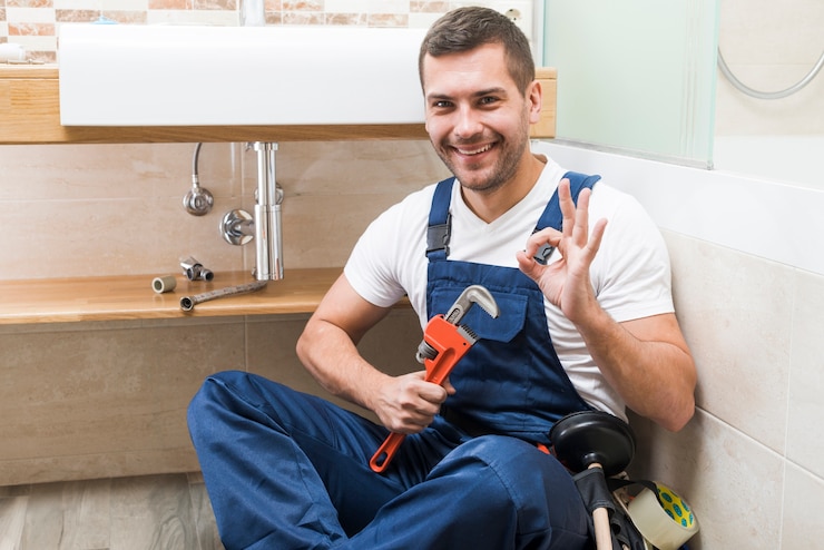 Photo cheerful plumber gesturing ok