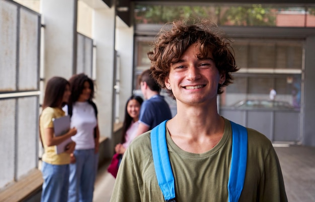 Cheerful portrait of a male high school student looking at camera smiling after class