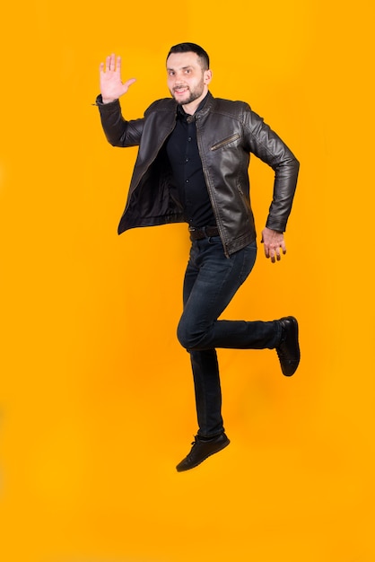 Cheerful positive man jumped on orange