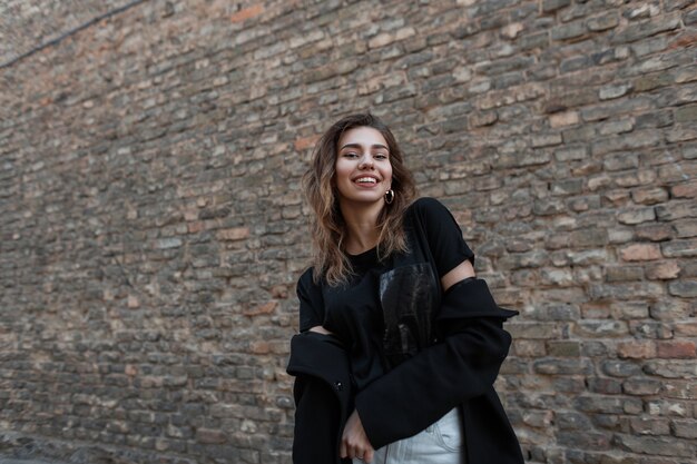 Cheerful positive young woman with a beautiful smile in fashionable clothes