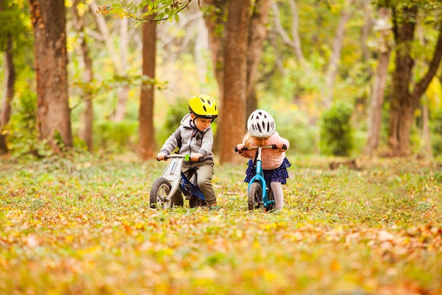 Cheerful preschool kids outdoors on balance bikes