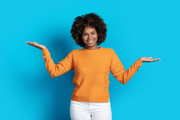 Cheerful pretty black woman holding something invisible on her hands