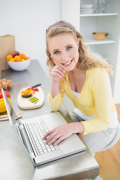 Cheerful pretty blonde using laptop