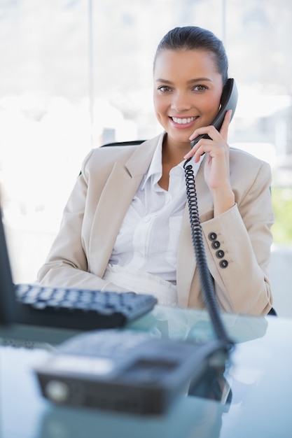 Cheerful pretty businesswoman answering the phone