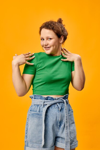 Cheerful pretty girl in summer clothes posing yellow background