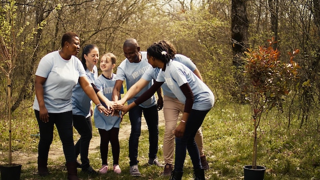 Cheerful proud team of activists join forces to clean a forest