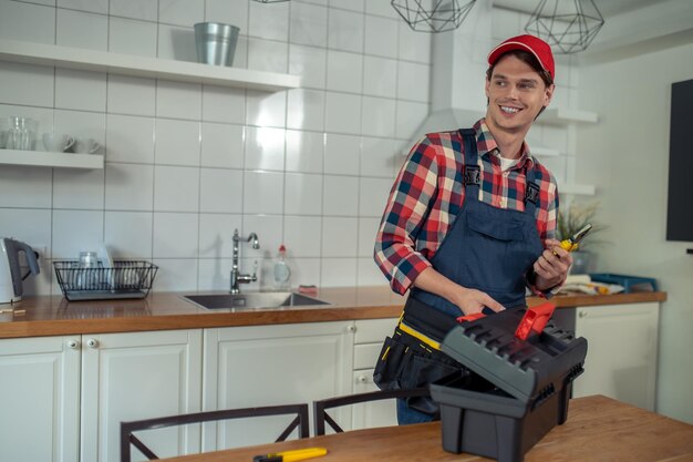 Photo cheerful repair technician preparing for work in a client apartment