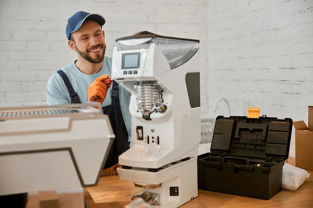 Cheerful repairman fixing coffee machine in cafe