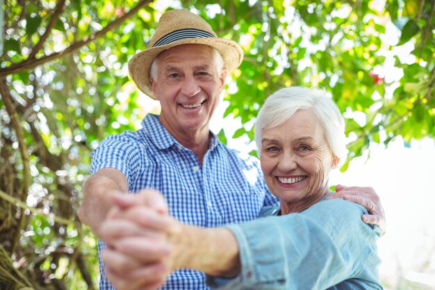 Cheerful retired couple dancing outdoors