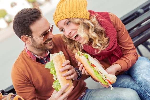 Foto coppia romantica allegra all'aperto godendo i panini