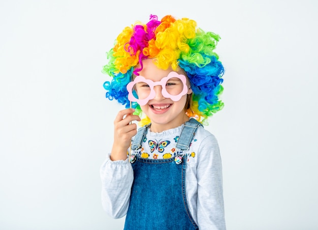 Cheerful schoolchild in rainbow wig