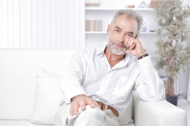 cheerful senior businessman sitting on the couch in the office.