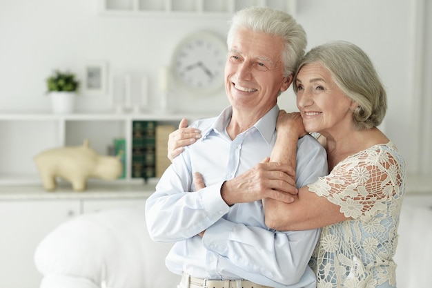 Cheerful senior couple embracing at home