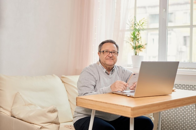 Cheerful senior man has phone conversation at home