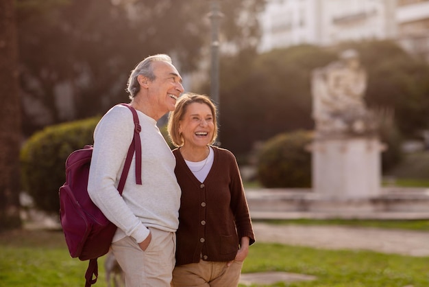 Cheerful Senior Travelers Couple Standing Looking Aside In Park Outdoors