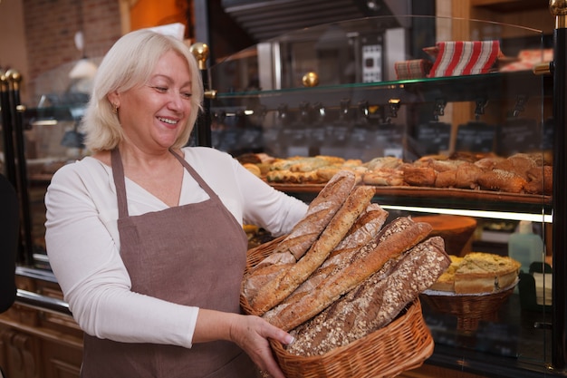 Cheerful senior woman wearing apron