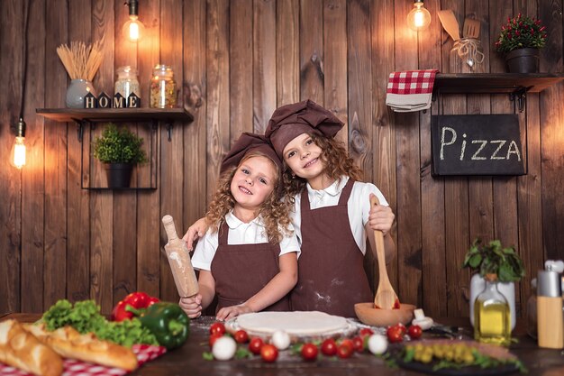 Cheerful sisters cooking pizza together