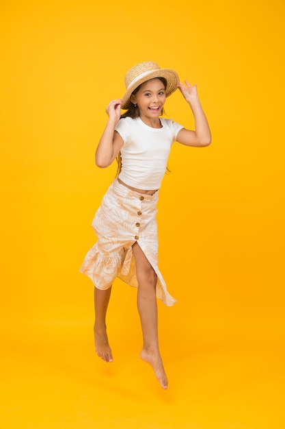 Cheerful small girl summer outfit jumping fly in air concept