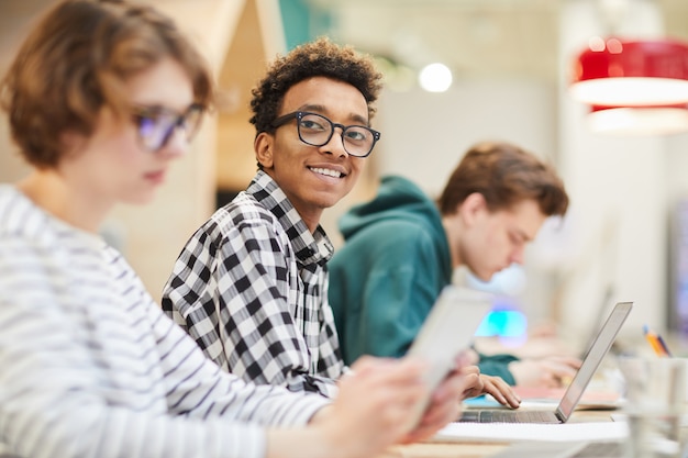 Photo cheerful smart black student using laptop