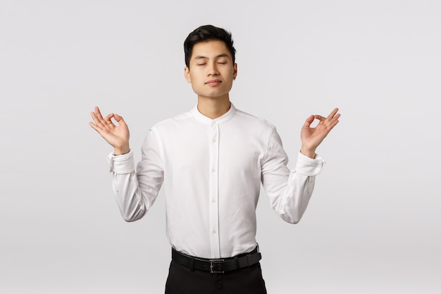 Cheerful smiling asian young entrepreneur with white shirt relieved