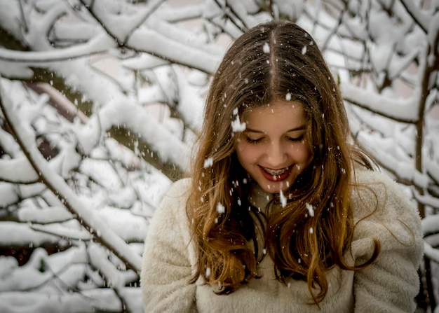 Cheerful smiling girl standing in snow